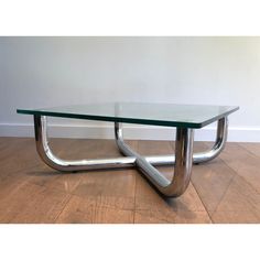 a glass and chrome coffee table on wooden floor