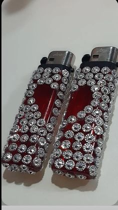 two red lighters with diamonds on them sitting next to each other in front of a white table