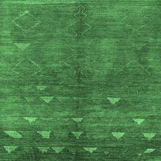 a green area rug with an intricate design on the top and bottom, along with triangles