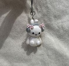 a keychain with a white and pink teddy bear on it's side