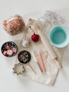 an assortment of items on a table including cake, cupcakes and other decorations