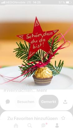 a small cupcake decorated with red stars on top of a white plate next to a christmas tree