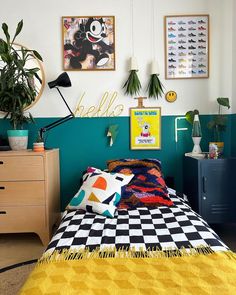 a bedroom with yellow and black checkered bedspread, potted plants and pictures on the wall