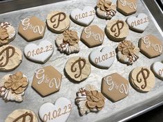 decorated cookies are arranged on a cookie sheet with the names and date in heart shapes