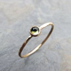 "To create this ring, I set a natural, untreated peridot onto a handmade, 14k gold bezel cup setting, textured to your specifications. Setting is perched atop the full-round halo band to allow for stacking flush with other rings in the same style. All metal components are solid 14k gold, and band measures just over 1mm thick. Peridot measures 3mm. Available finishes, shown in photo four, are as follows: - Smooth - Hammered - Notched - Matte - Matte Hammered - Matte Notched ROSE CUT peridot is al Stackable Yellow Gold Peridot Jewelry, Yellow Gold Peridot Stackable Rings, Stackable Round Peridot Jewelry, Fine Jewelry Hand Forged Stackable Rings, Hand Forged Dainty Stackable Rings, Gold Peridot Ring, Mid Finger Rings, Mother's Ring, Gemstone Stacking Ring