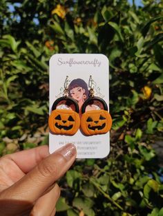 someone is holding up some earrings that look like pumpkins