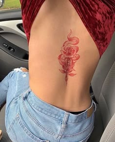 a woman's lower back tattoo with roses on her left side ribcage