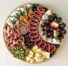 a platter filled with fruit, crackers and cheeses