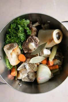 a metal bowl filled with vegetables and meat