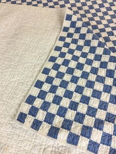 a blue and white checkered quilt on top of a bed