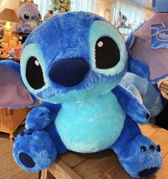 a blue stuffed animal sitting on top of a wooden table