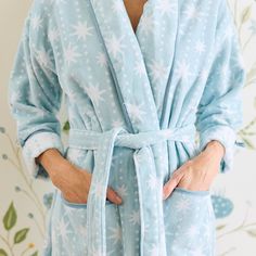 a woman wearing a blue robe with white snowflakes on it