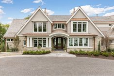 a large house with lots of windows on the front and side of it's facade