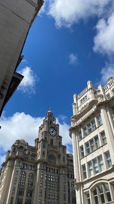 two tall buildings with a clock on the top and sky in the backgroud