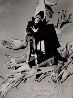 black and white photograph of man surrounded by many hands