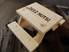 a wooden stool with the words dez nuts written on it