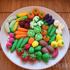 a white plate topped with lots of fake vegetables