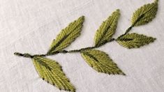 a close up of a piece of cloth with some leaves on it and one leaf has been stitched into the fabric