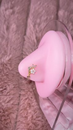 a pink pacifier sitting on top of a glass stand next to a fur rug