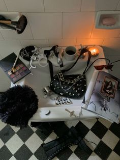 a table topped with purses and other items next to a lamp on top of a checkered floor