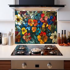 a stove top oven sitting inside of a kitchen next to a wall covered in flowers