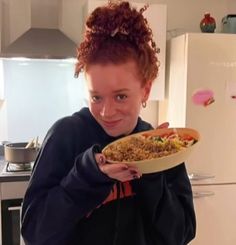 a woman holding a plate of food in her hands