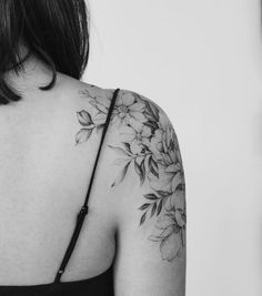 the back of a woman's shoulder with flowers on it