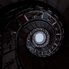 a spiral stair case in the middle of a building with light coming from it's center