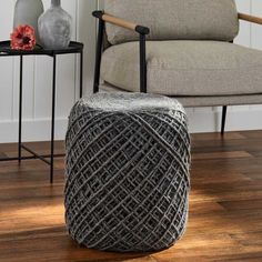 a gray stool sitting on top of a hard wood floor