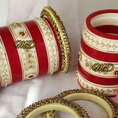 three red and white bangles with gold trimmings are on the table next to each other