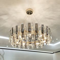 a chandelier hanging from the ceiling in a room with marble walls and flooring