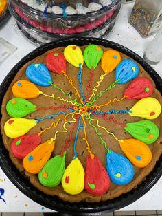 a cake decorated with colorful icing on top of a table