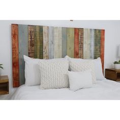 a bed with two white pillows on top of it next to a wooden headboard