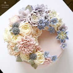 a cake decorated with flowers on top of a white table cloth covered in icing