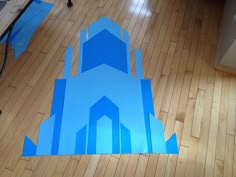 the floor is covered in blue paper and has a clock tower on it's side