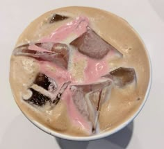 a cup filled with liquid and ice on top of a table