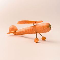 a toy airplane made out of carrots on a white background