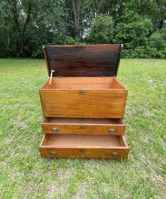 an old wooden chest sitting in the grass