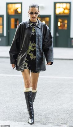 a woman walking down the street wearing black boots