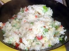 a bowl filled with rice and vegetables on top of a table