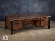 a wooden desk with two drawers on the bottom and one drawer at the top, in front of a gray wall