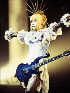 a woman dressed in white holding a blue guitar