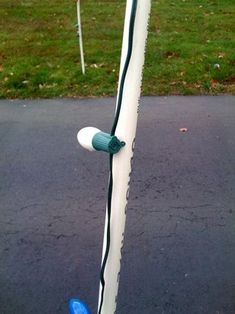 a baseball bat is leaning against the post on the side of the road with grass in the background