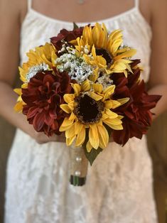 a bride holding a bouquet of sunflowers and other flowers