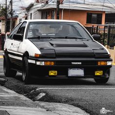 a black and white car is parked on the street