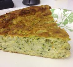 a piece of quiche on a paper plate with a green and white flowered napkin