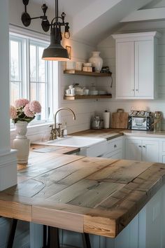 a kitchen with an island made out of wooden planks and hanging lights over the sink