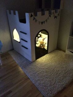 a room with a castle shaped bed and rugs on the floor in front of it