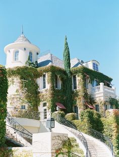 an old mansion with ivy growing all over it's walls and staircase leading up to the upper floor