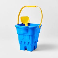 a blue bucket with a yellow handle and a plastic shovel in the bottom, on a white background